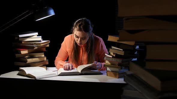 Girl Goes Through the Book and Find the Right Information. Black Background alt