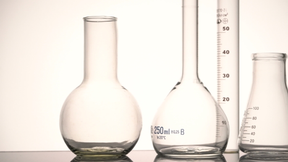 Empty Chemical Glass Flasks and Test Tube Reflecting on the Surface