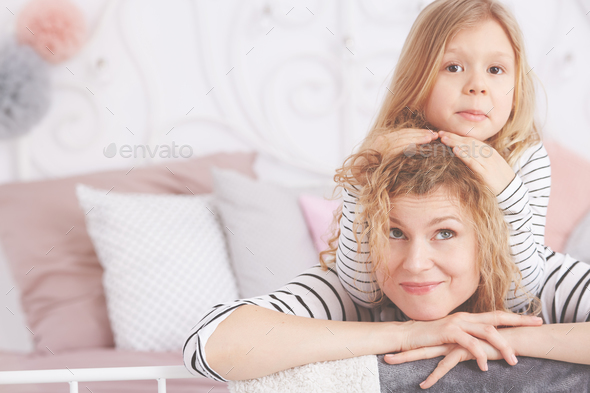 Girl leaning on mom\'s head