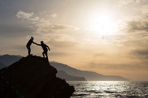 Teamwork couple climbing hiking with helping hand