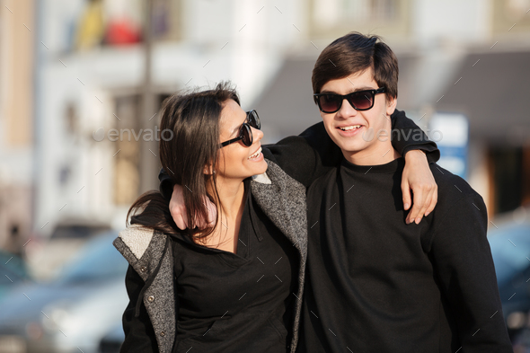 Happy young woman walking outdoors with her brother - Stock Photo - Images