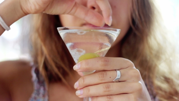 The Girl Is Holding a Glass with a Martini Cocktail and Olives