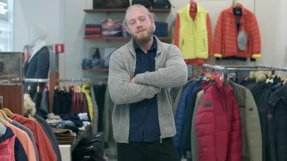 Confident Handsome Bearded Man Posing in Clothing Shop During Black Friday Sales. Portrait of alt