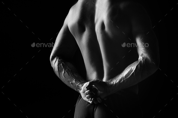 The back view torso of attractive male body builder on black background. Stock Photo by master1305