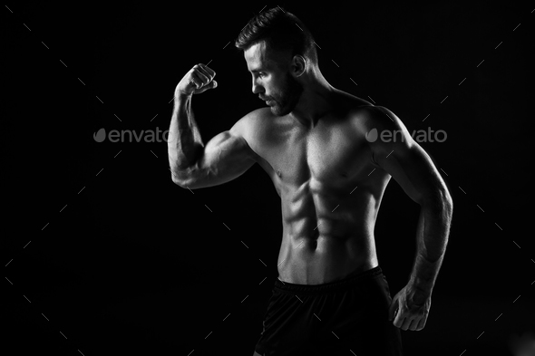 The torso of attractive male body builder on black background. - Stock Photo - Images