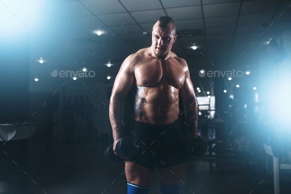Strong male bodybuilder with pancakes from barbell - Stock Photo - Images
