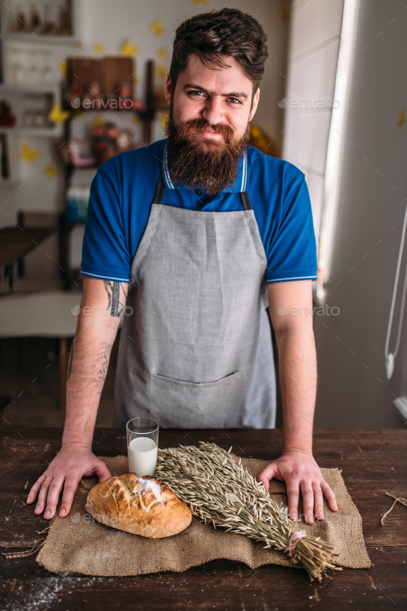 Baker against bread, wheat, milk on burlap cloth - Stock Photo - Images