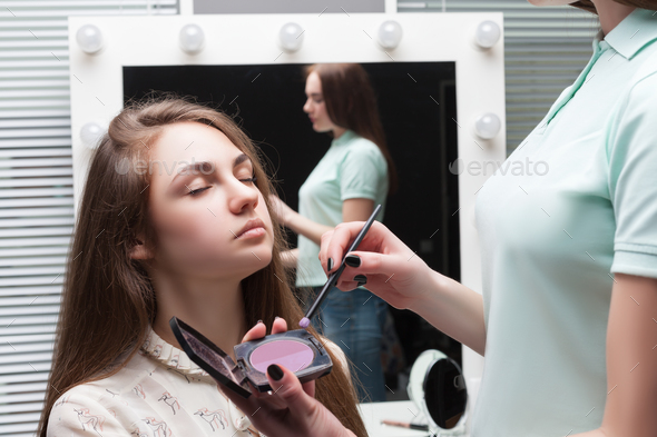 Make up artist applying make-up on girl face - Stock Photo - Images