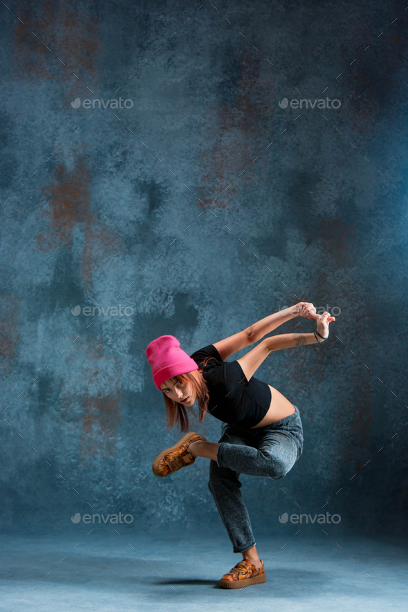 Young girl break dancing on wall background. Stock Photo by master1305
