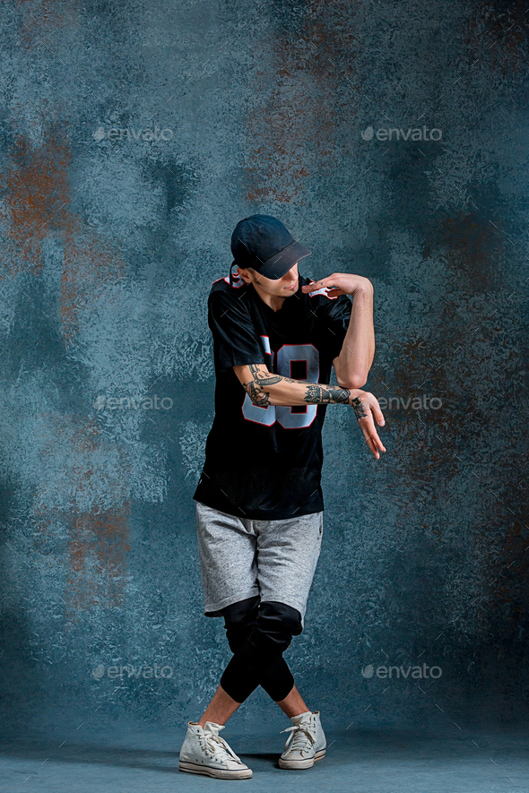 Young man break dancing on wall background. Stock Photo by master1305
