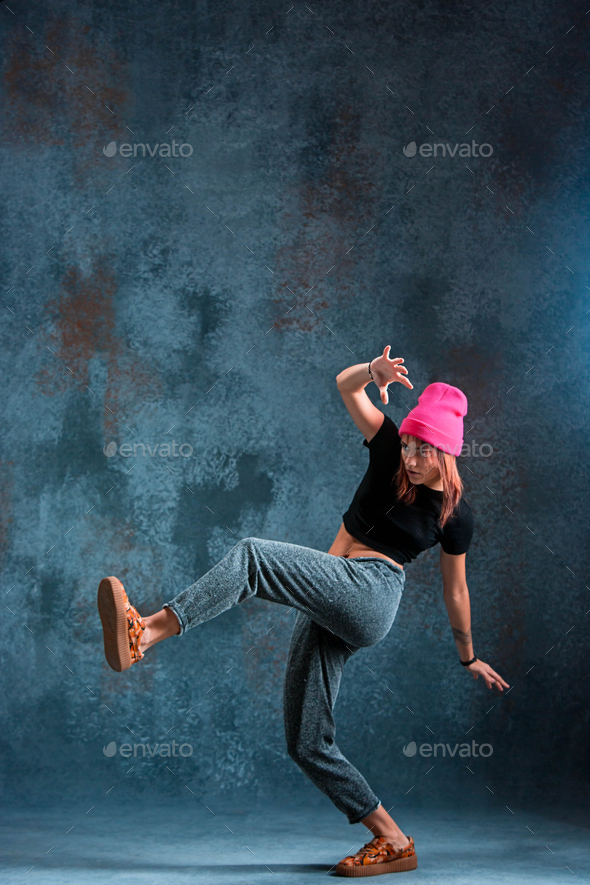 Young girl break dancing on wall background. Stock Photo by master1305