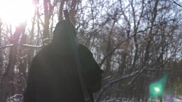 Hunting Hunter Men with Gun Walking Through the Forest During the Hunting Season. alt