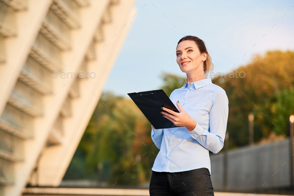 Businesswoman with clipboard smiling