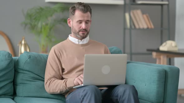 Man with Laptop Taking Nap on Sofa alt