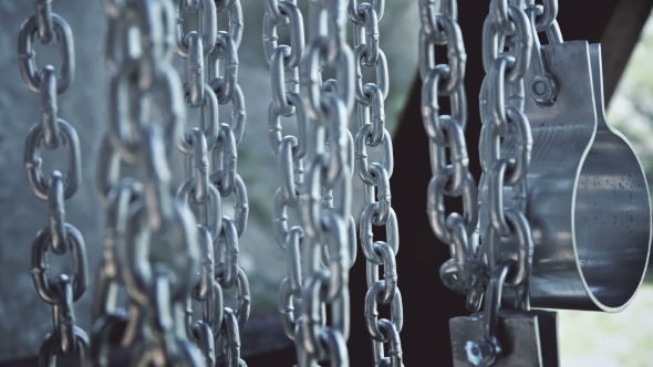 Chains with Shackles Hanging in an Abandoned Building alt