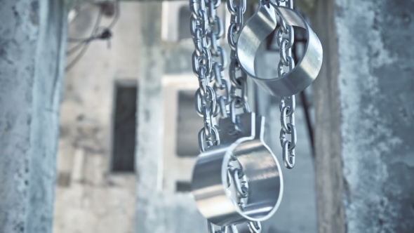 Chains with Shackles Hanging in an Abandoned Building alt
