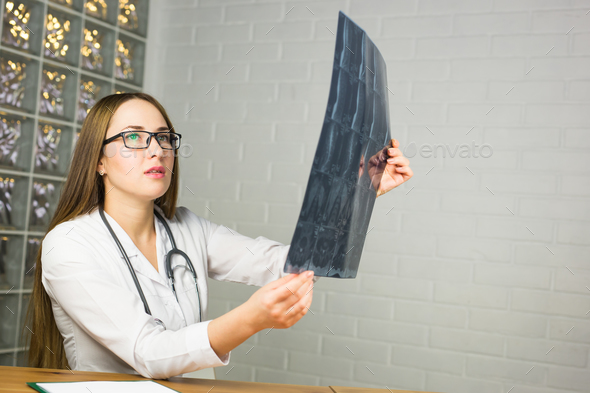 Woman Doctor Looking at X-Ray Radiography in doctor\'s office