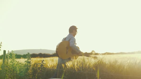Musician rehearsing in wheat field during beautiful sunset alt