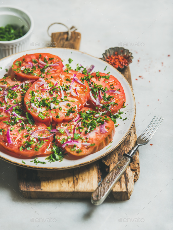 Fresh heirloom tomato, parsley and onion salad on wooden board - Stock Photo - Images