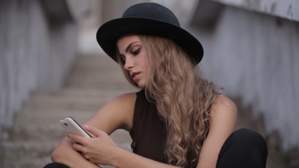 Young Beautiful Girl in a Black Hat Smiling