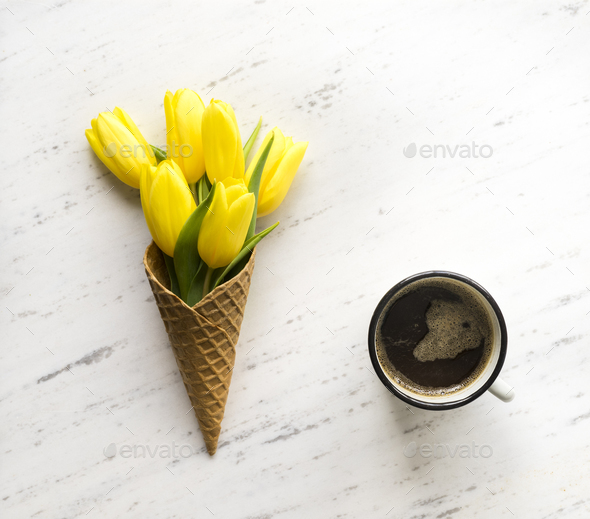 Tulips in ice cream cone on marble background