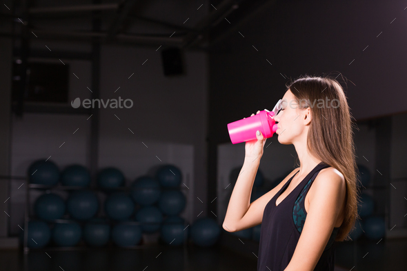 healthy fitness girl with protein shake. sport and work out girl in gym
