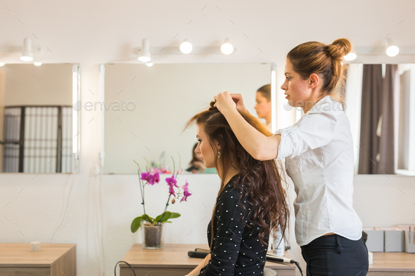 working day inside the beauty salon. Hairdresser makes hair styling