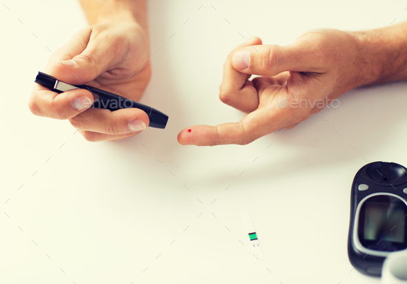 close up of man checking blood sugar by glucometer - Stock Photo - Images