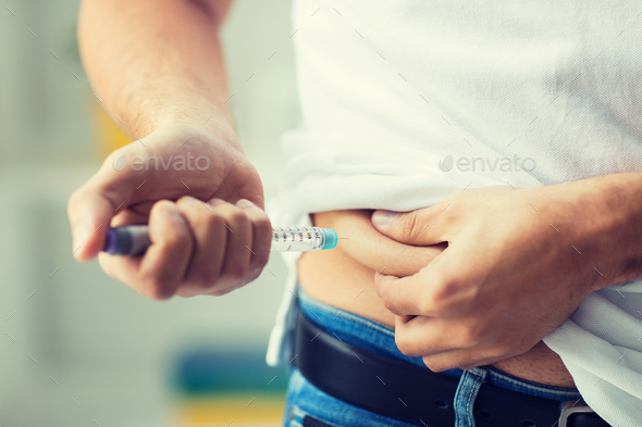 man with syringe making insulin injection - Stock Photo - Images