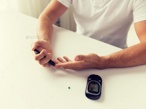 close up of man checking blood sugar by glucometer - Stock Photo - Images