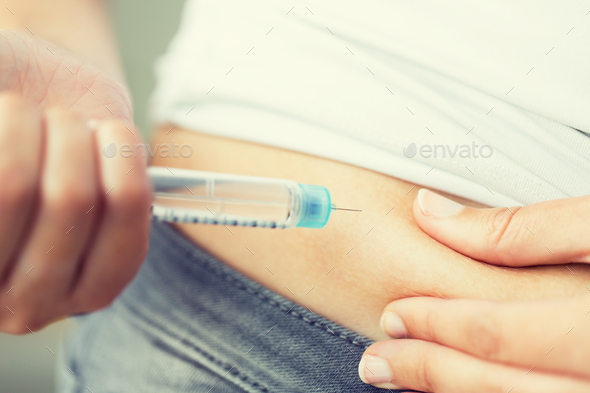 close up of hands making injection by insulin pen - Stock Photo - Images