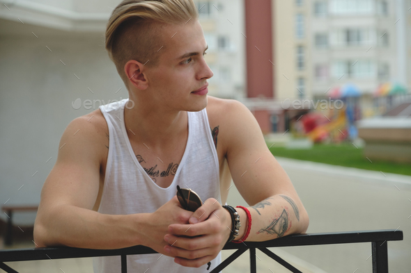 Hipster handsome blonde man guy in stylish summer clothes in the street Stock Photo by arthurhidden