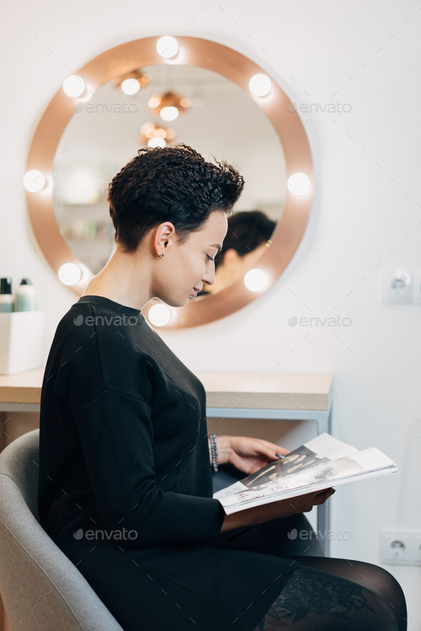 Attractive woman at the mirror in beauty studio - Stock Photo - Images