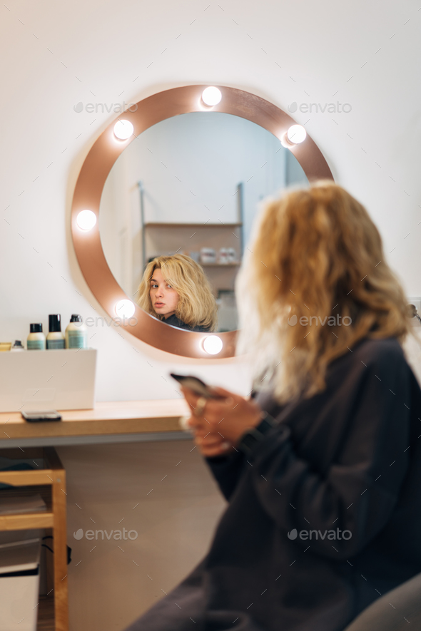 Attractive woman at the mirror in beauty studio - Stock Photo - Images