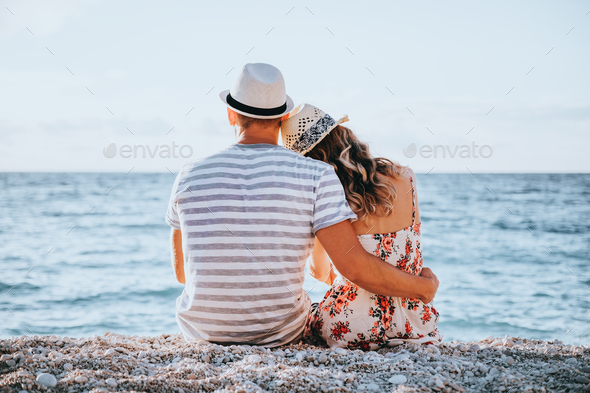 Young couple in love sitting on the beach - Stock Photo - Images