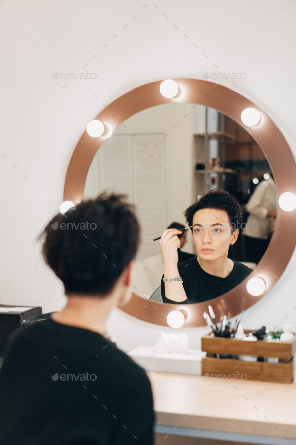 Attractive woman at the mirror in beauty studio - Stock Photo - Images