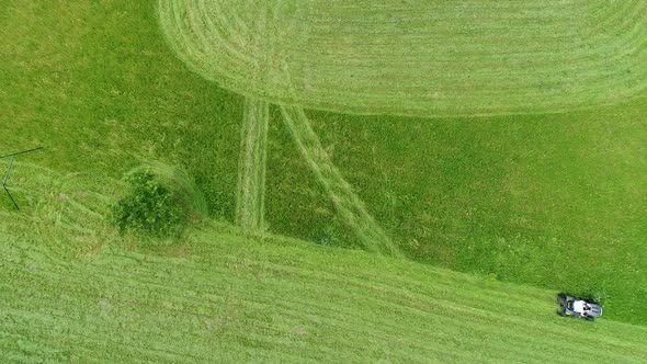 Riding lawn mower in action seen from the sky alt