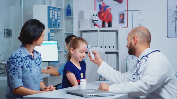 Pediatrician Checking Ontemperature alt