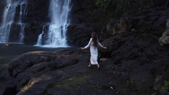 Young beautiful sexy woman in long white dress go to waterfall Tad Yuang, Laos Asia, Travel, 4K Slow
