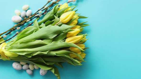 Holiday Contept Decoration with Easter Eggs and Yellow Tulips Over Blue alt