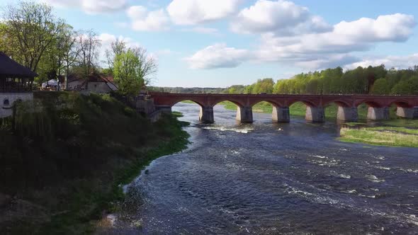 Venta Rapid Waterfall, the Widest Waterfall in Europe and Long Brick Bridge, Kuldiga, Latvia. alt