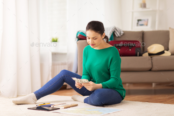 happy woman with money and travel map at home