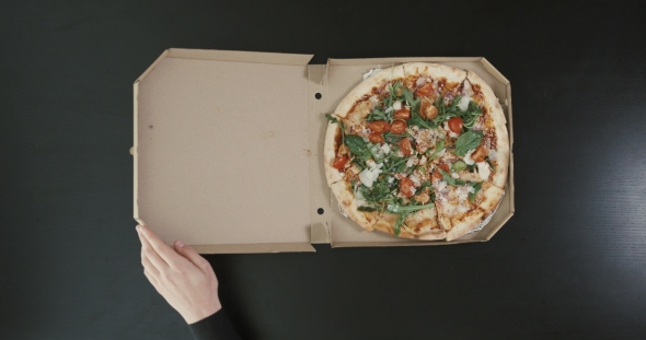 The  Above View of the Hands of the Man Are Opening the Box with the Pizza