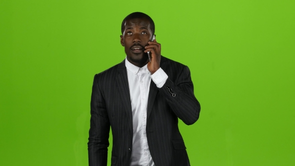 Businessman Takes the Phone and Starts Talking on the Phone. Green Screen alt