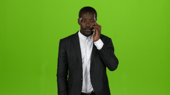 African American Is Talking on the Phone, Everything Is Shaking Him. Green Screen alt