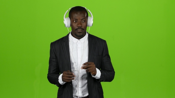 Black African Guy Listens To Music Through Headphones and Sings Along. Green Screen alt