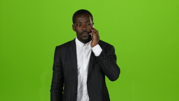 African American Is Talking on the Phone, Everything Is Shaking Him. Green Screen alt
