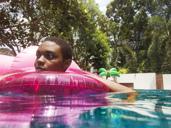 Closeup of african descent woman floating in the pool with infla