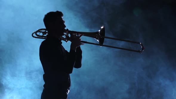 Silhouette Musician Man Playing on Trombone. Smoky Studio, Slow Motion alt