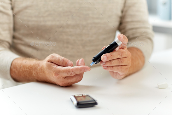 close up of old man with glucometer blood test - Stock Photo - Images